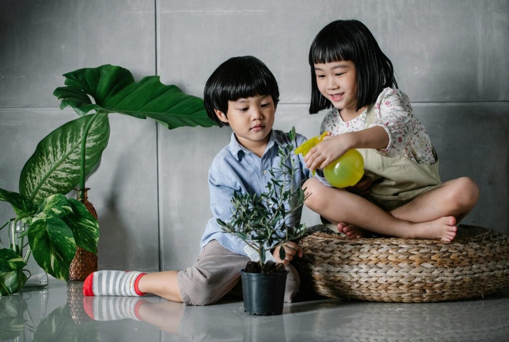 cute kids are watering indoor plants